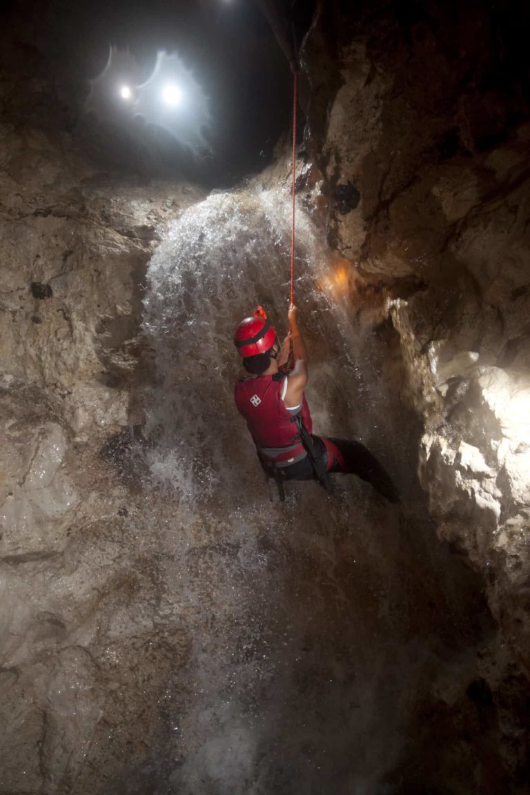 belize waterfall rappelling cave expedition female adventure web